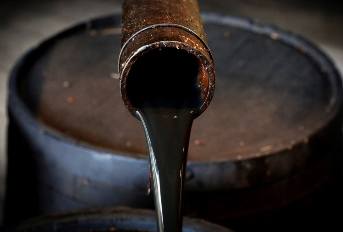Plataforma petrolera con bandera de Irán y gráfico de caída del crudo