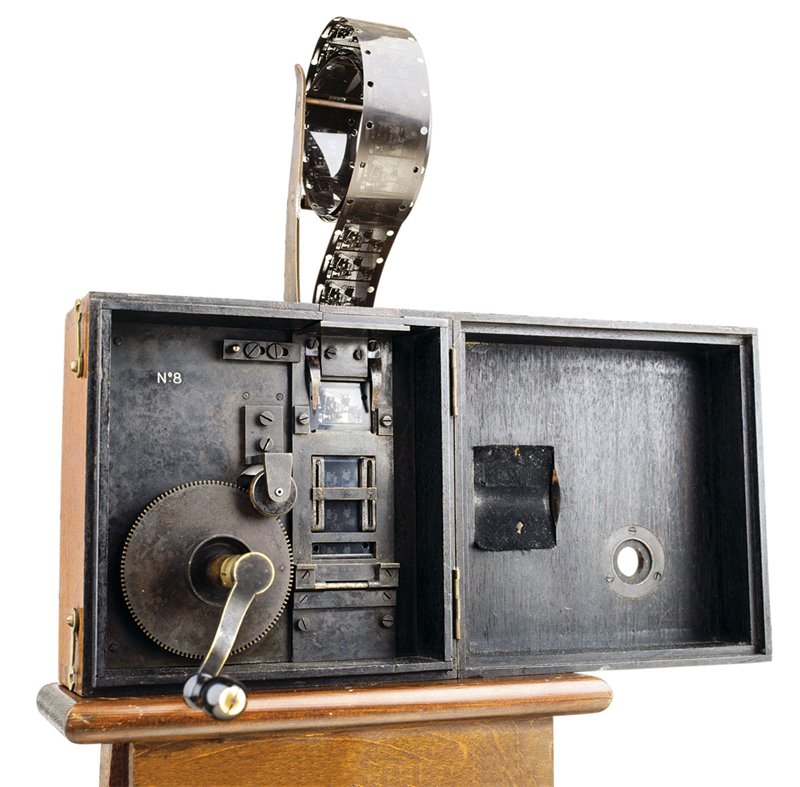 Cinematógrafo inventado por los hermanos Lumière, 1895. El aparato consistía en una caja de madera con un objetivo y una película perforada de 35 milímetros. Ésta se hacía rodar mediante una manivela para tomar las fotografías instantáneas que componían la secuencia (que no duraba más de un minuto) y proyectar luego la filmación sobre una pantalla.
