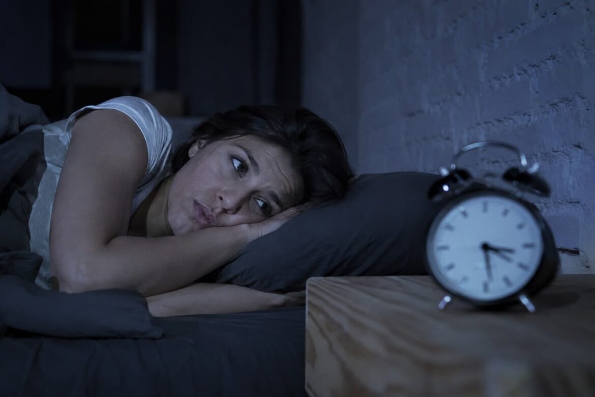 Persona despierta en la noche con ansiedad y pensamientos repetitivos